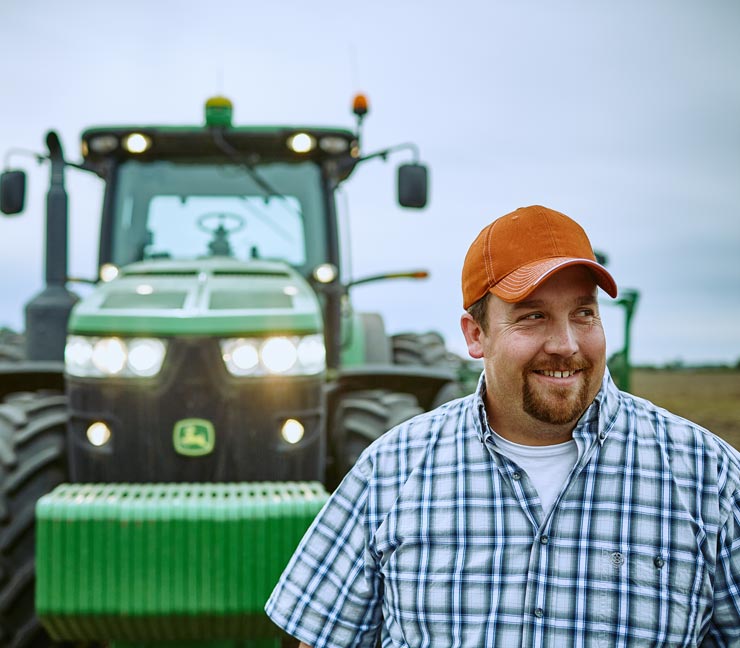 Farm Funding customer standing in a field during spring planting